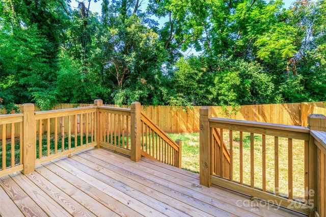 a balcony with wooden floor and trees in the back