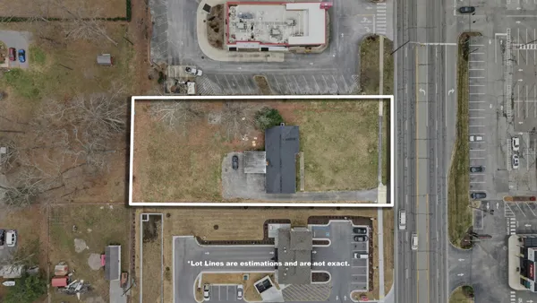 a view of a yard in front of a house with large trees