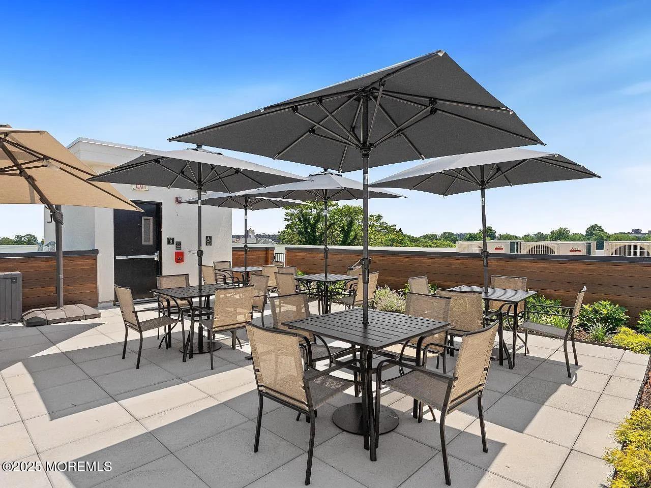 27 3rd Avenue, Unit 210 Long Branch, NJ 07740 - Photo 21 of 28 a view of patio with chairs and table under an umbrella
