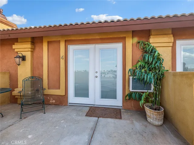 a view of a patio with a table and chairs under an umbrella
