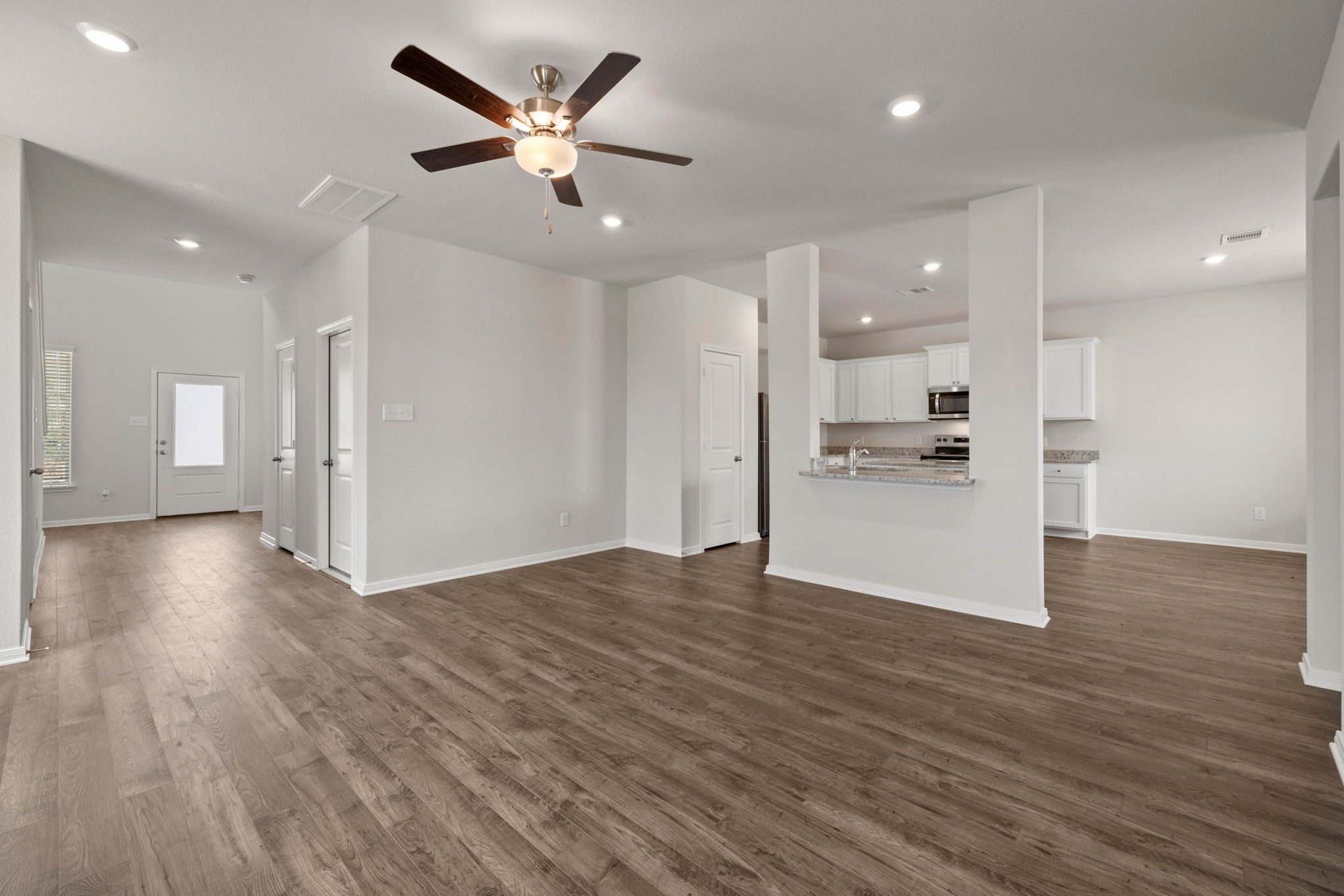 7610 Thrips Lane Richmond, TX 77469 - Photo 4 of 20 a view of empty room with wooden floor and kitchen view
