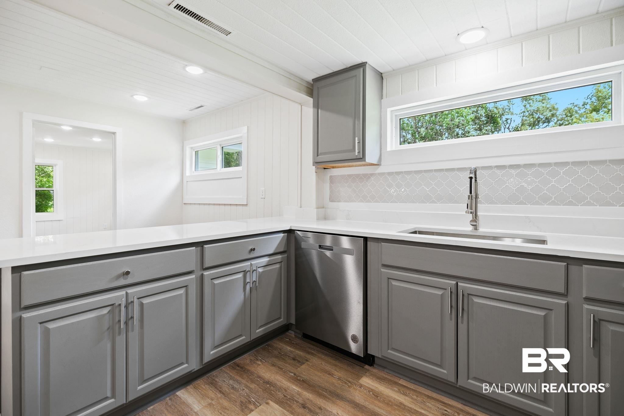 507 Byrne Street Bay Minette, AL 36507 - Photo 11 of 40 Kitchen featuring tasteful backsplash, dishwasher, dark hardwood / wood-style flooring, sink, and gray cabinetry