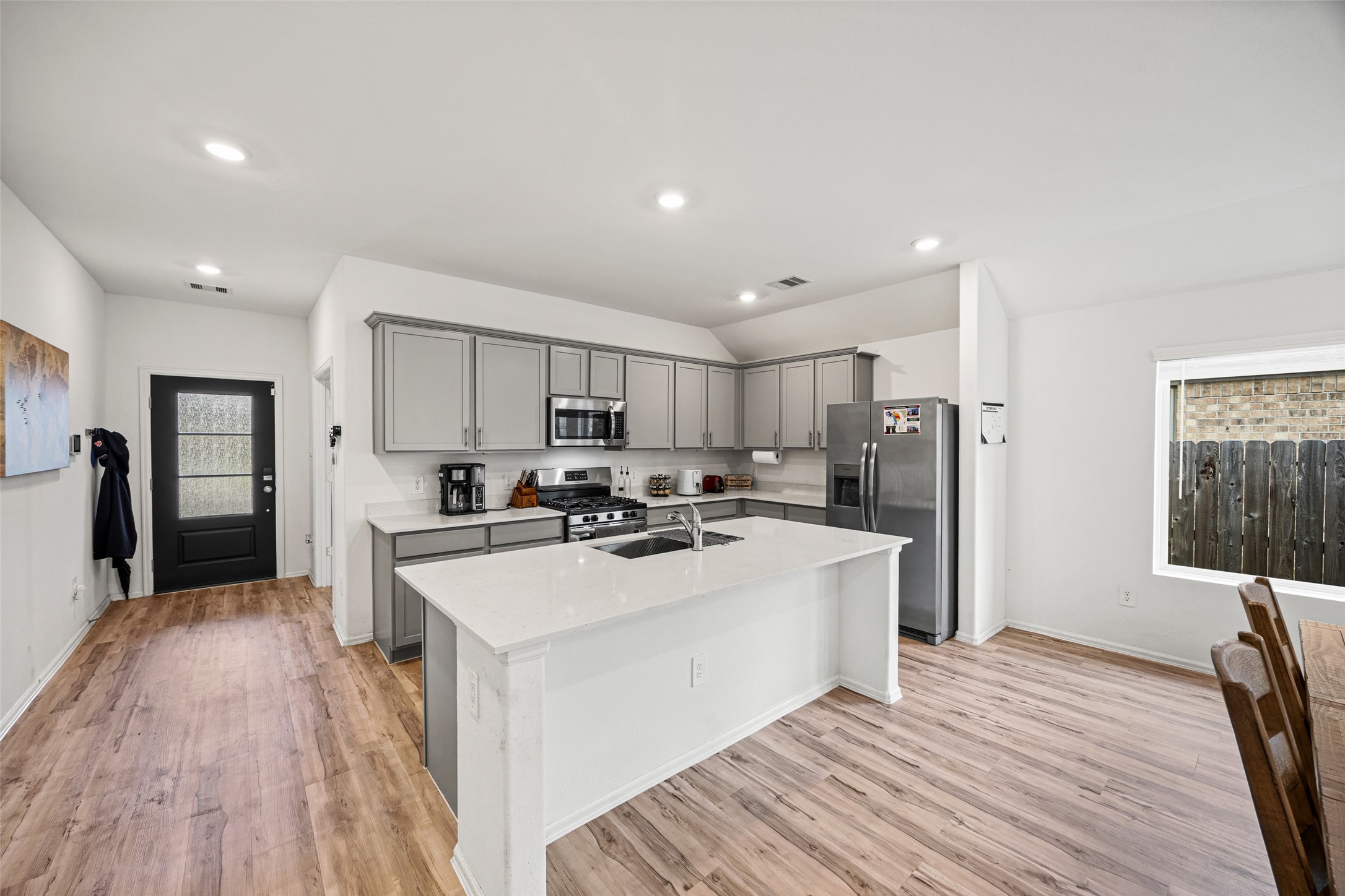 2822 Paradise Ridge Way Conroe, TX 77301 - Photo 8 of 21 a kitchen with stainless steel appliances a stove top oven a refrigerator and white cabinets with wooden floor