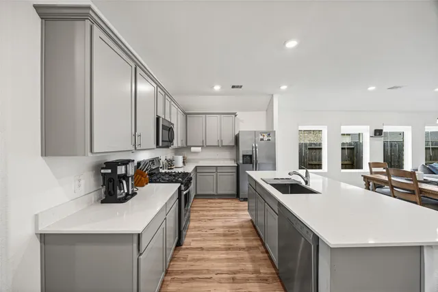 a kitchen with a sink stove and cabinets