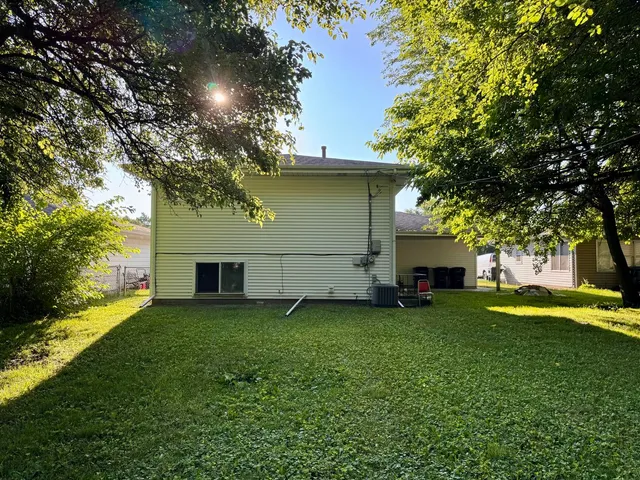 a view of a house with a yard and tree
