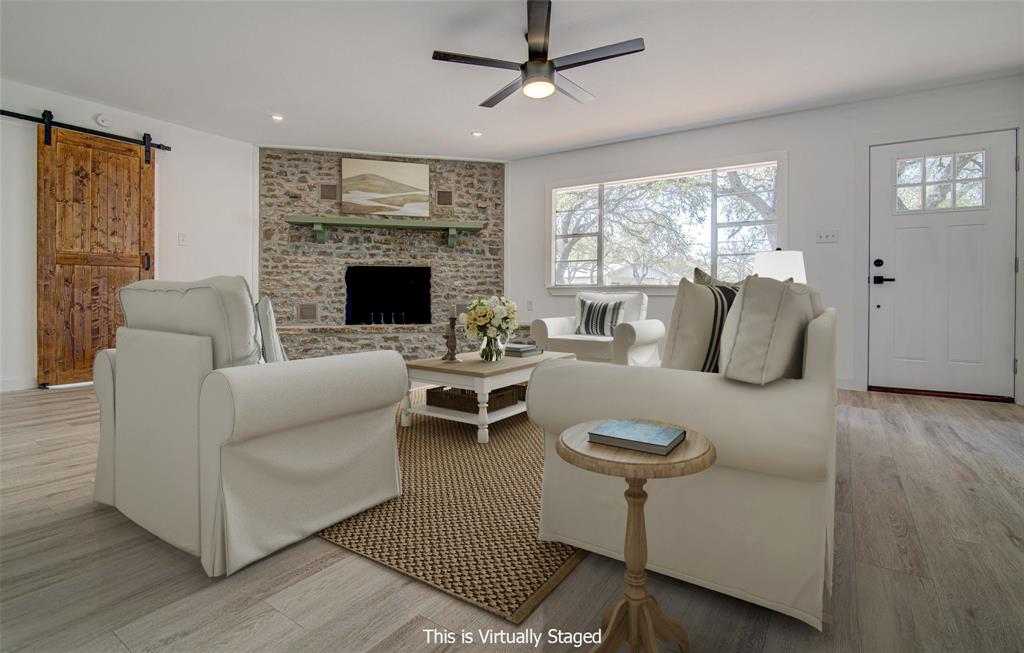 207 Haley Road Johnson City, TX 78636 - Photo 1 of 31 A welcoming living area boasts a captivating stone fireplace and generous natural light.