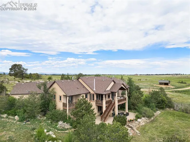 an aerial view of a house with a garden and lake view