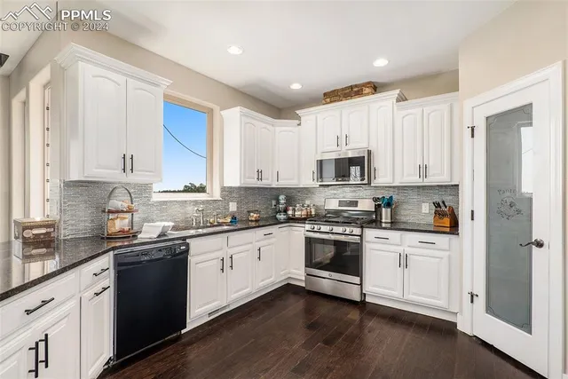 a kitchen with white cabinets and stainless steel appliances