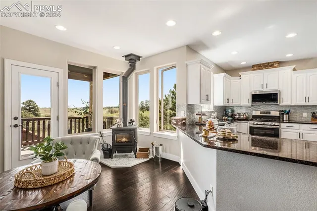 a kitchen with granite countertop white cabinets and stainless steel appliances