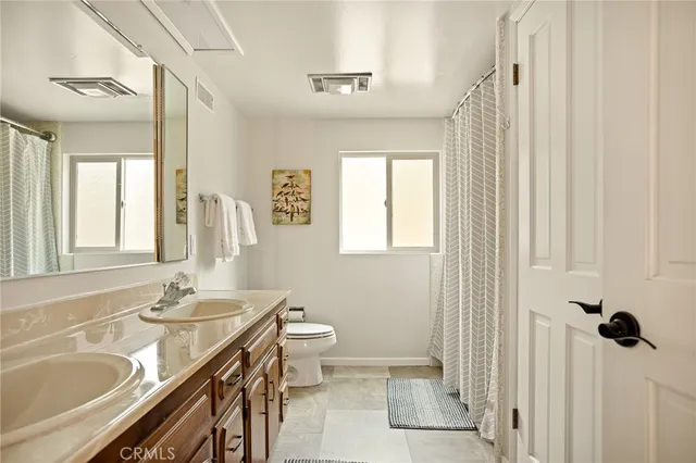 a bathroom with a granite countertop sink toilet a mirror and shower
