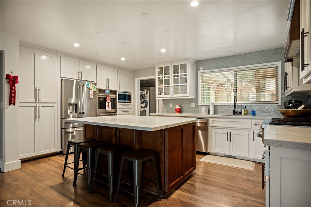 435 Riviera Drive Lake Arrowhead, CA 92352 - Photo 9 of 39 a kitchen with stainless steel appliances granite countertop a table chairs stove top oven and refrigerator