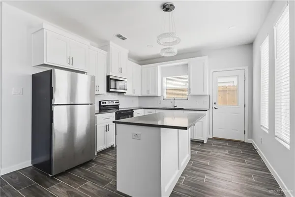 a kitchen with stainless steel appliances granite countertop a refrigerator a sink and a stove