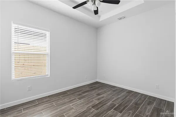 an empty room with a window and a ceiling fan