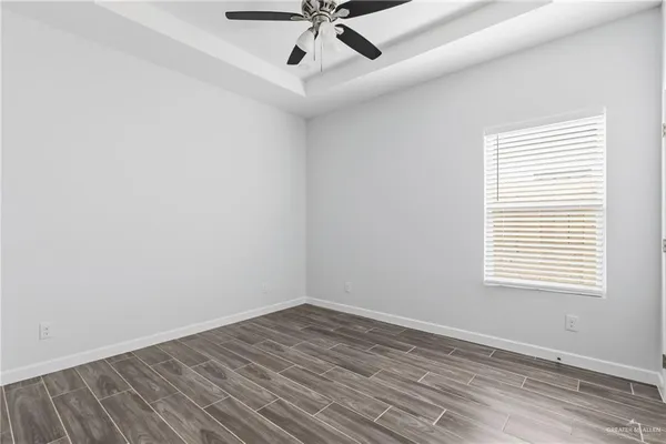 an empty room with a window and ceiling fan
