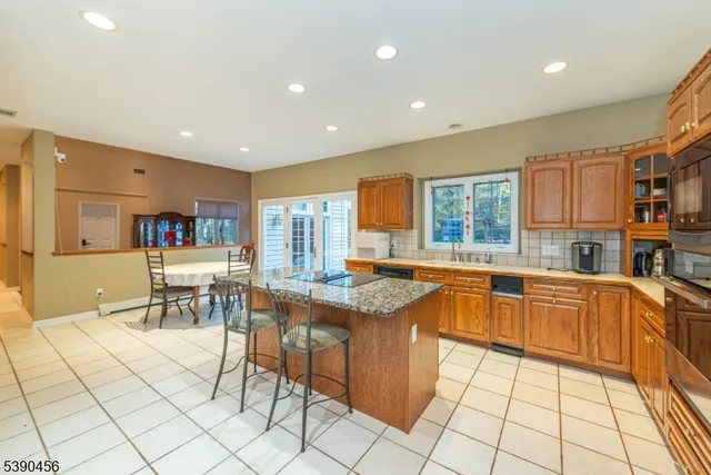 a kitchen with stainless steel appliances granite countertop a refrigerator and a stove top oven