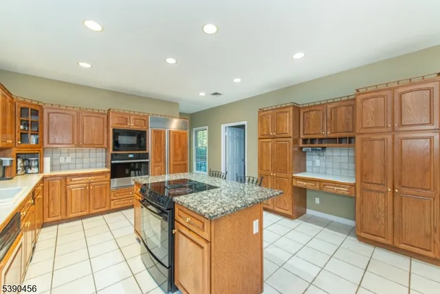 a kitchen with stainless steel appliances granite countertop a refrigerator and a sink