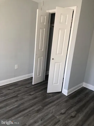 an empty room with wooden floor and staircase
