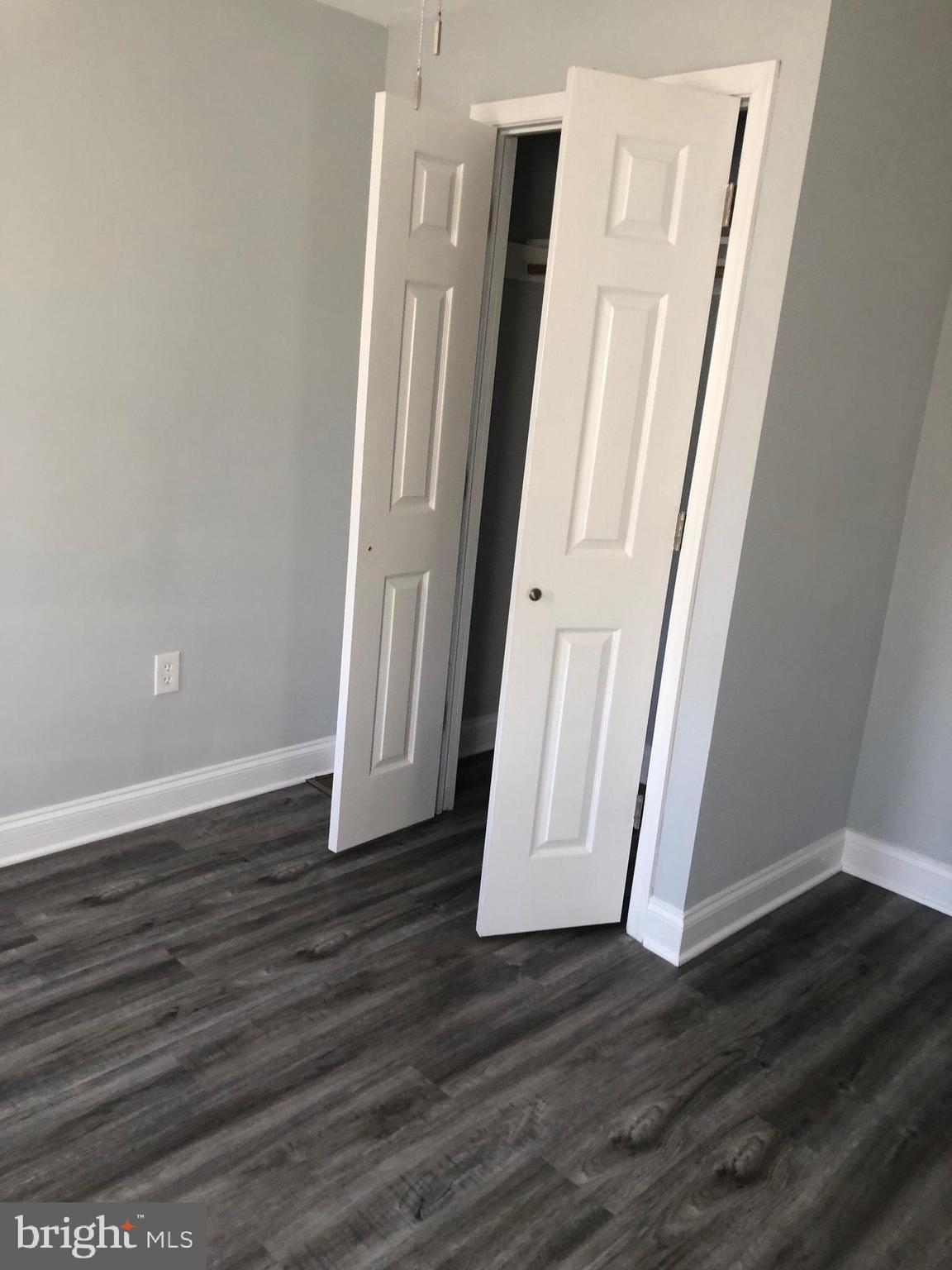 2123 East Chase Street Baltimore, MD 21213 - Photo 13 of 21 an empty room with wooden floor and staircase