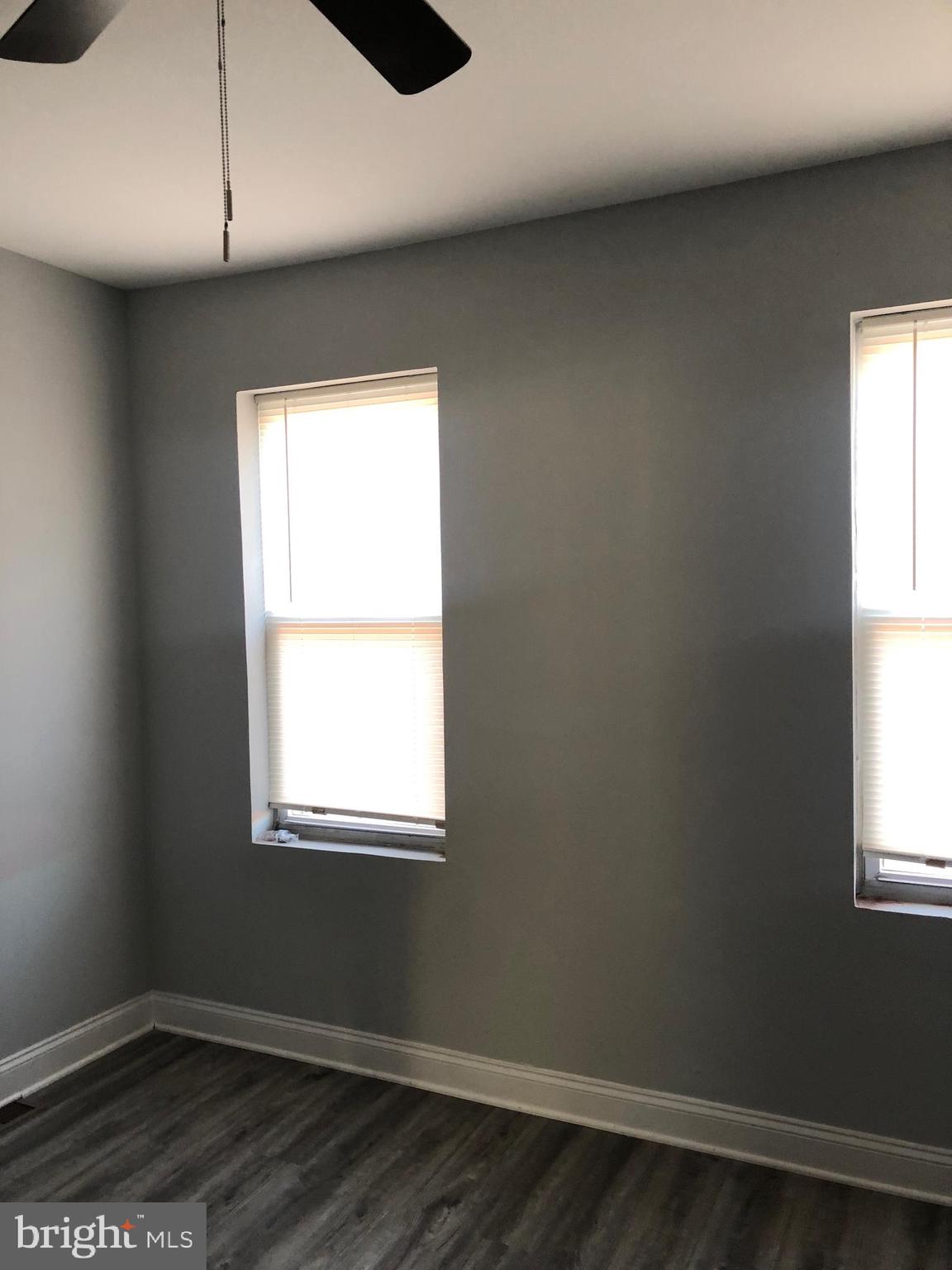 2123 East Chase Street Baltimore, MD 21213 - Photo 19 of 21 an empty room with wooden floor and windows