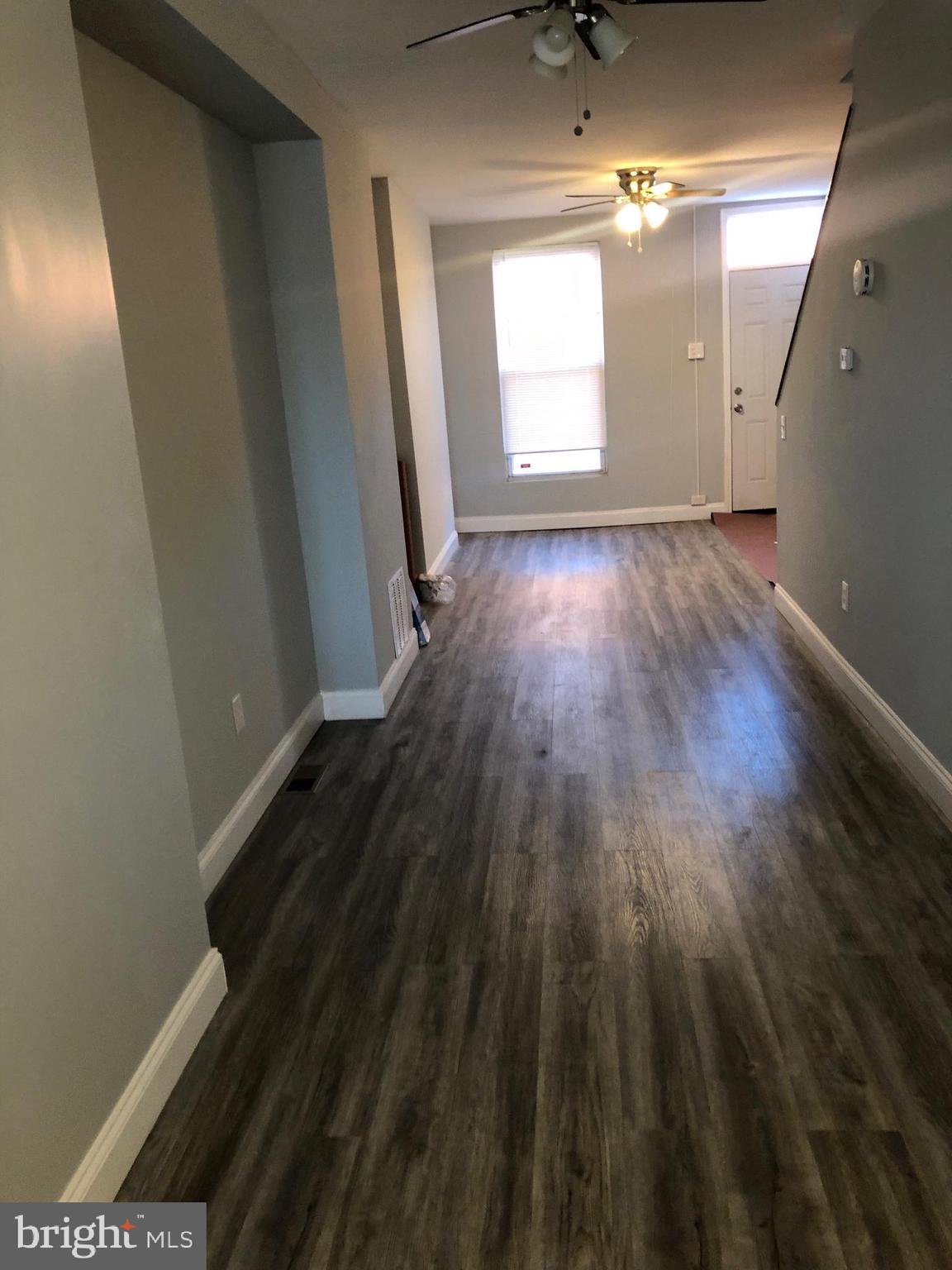 2123 East Chase Street Baltimore, MD 21213 - Photo 3 of 21 a view of a room with wooden floor and windows