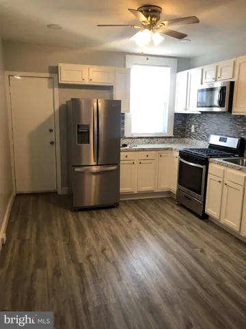 a kitchen with granite countertop a refrigerator and a sink