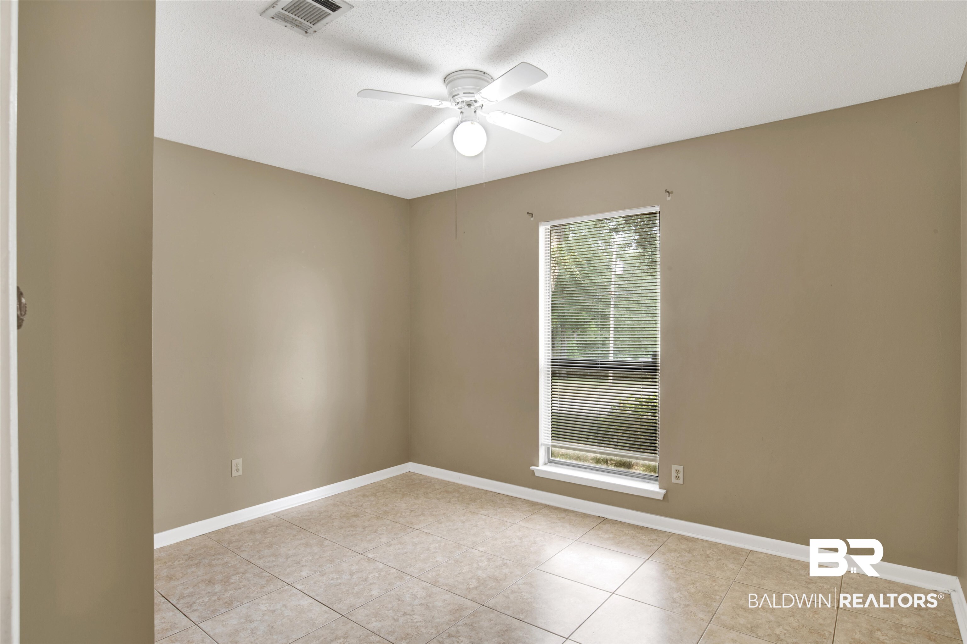 3560 Creekway Road Mobile, AL 36619 - Photo 21 of 24 Empty room with a textured ceiling, light tile patterned floors, and ceiling fan