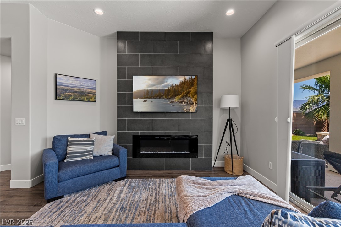1436 Manassas Ridge Mesquite, NV 89027 - Photo 21 of 77 A sleek fireplace feature wall with a large TV creates a cozy atmosphere in this open-concept living space.