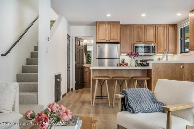 a kitchen with kitchen island granite countertop a sink refrigerator and cabinets