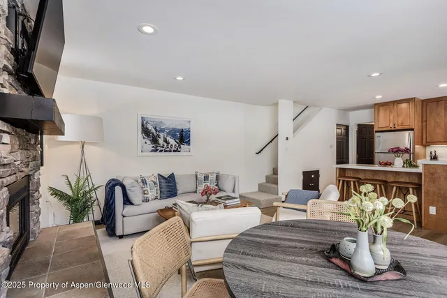 a living room with furniture potted plant and kitchen view