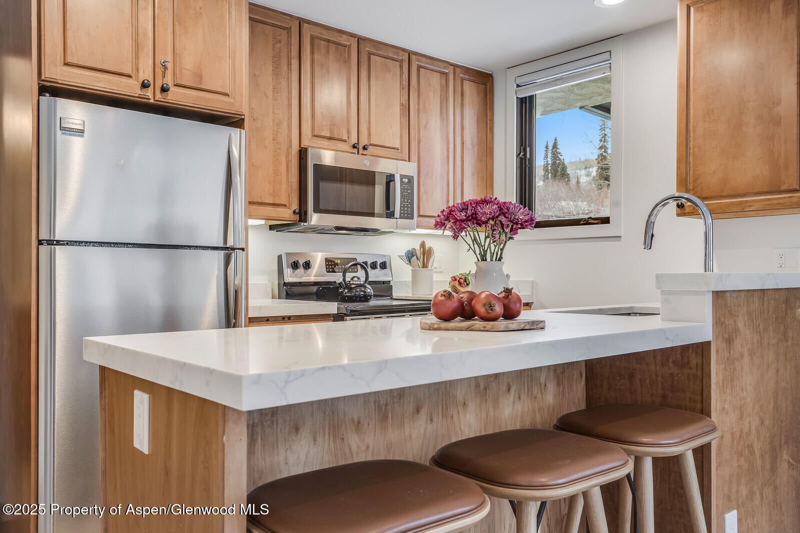 135 Carriage Way, Unit 5 Snowmass Village, CO 81615 - Photo 13 of 59 a kitchen with stainless steel appliances a dining table chairs microwave and sink