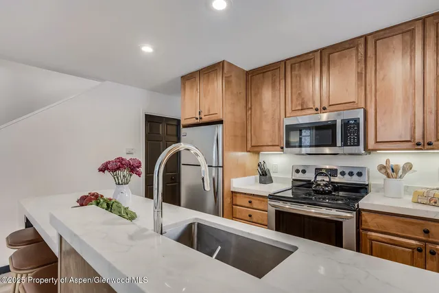 a kitchen with granite countertop a sink stainless steel appliances and cabinets