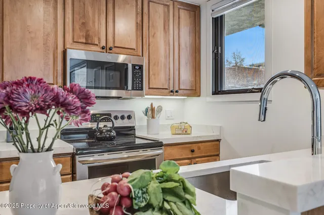 a kitchen with stainless steel appliances granite countertop a stove a sink and a microwave