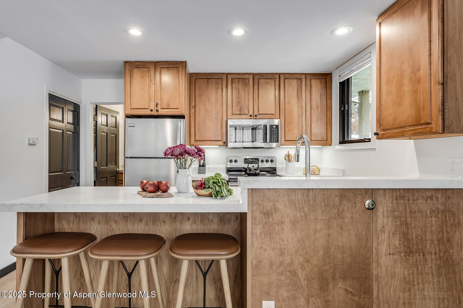 135 Carriage Way, Unit 5 Snowmass Village, CO 81615 - Photo 17 of 59 a kitchen with granite countertop a sink and white cabinets