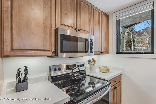 a kitchen with stainless steel appliances granite countertop a sink stove and microwave