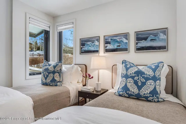 a spacious bedroom with a bed and a flat screen tv