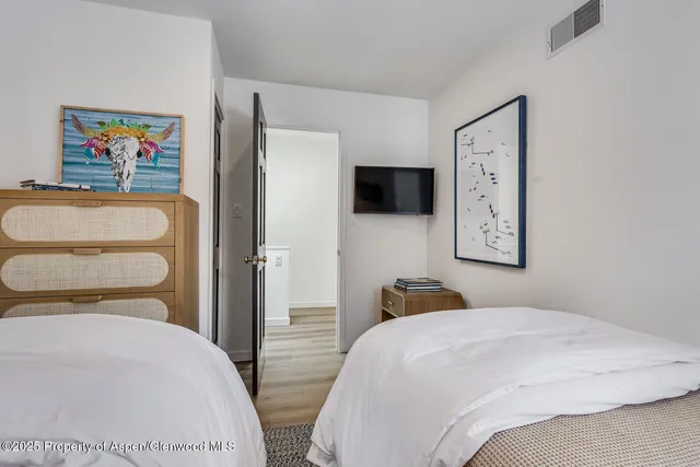 a bedroom with a bed and a flat screen tv