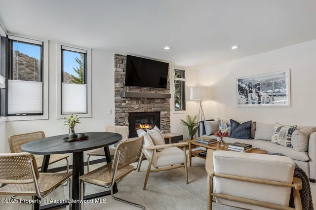 a living room with furniture a flat screen tv and a fireplace