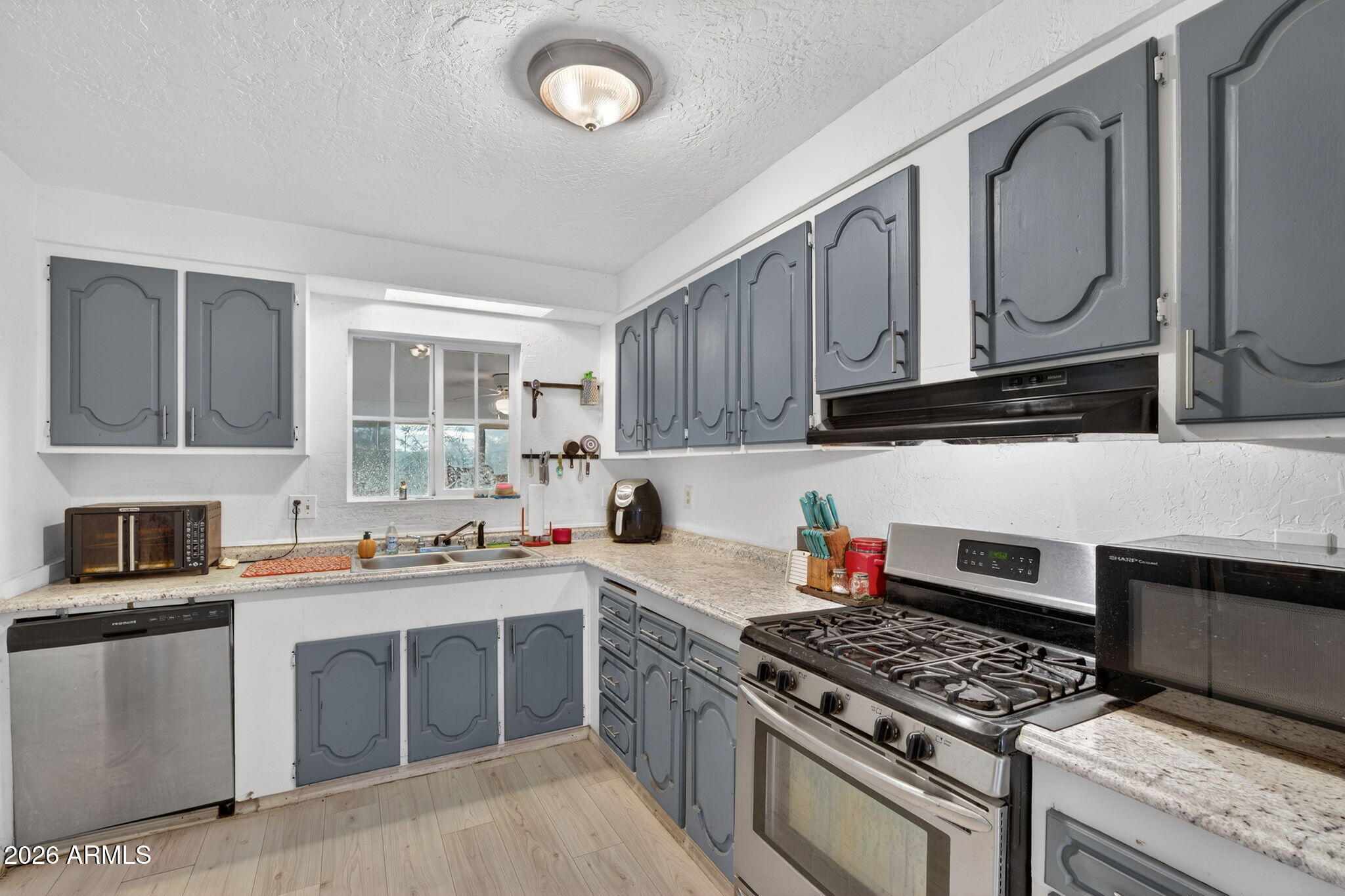 19500 West Bobcat Road Casa Grande, AZ 85122 - Photo 3 of 34 a kitchen with stainless steel appliances granite countertop a stove top oven a sink dishwasher and cabinets with wooden floor