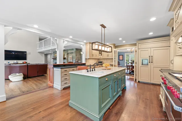 a kitchen with kitchen island granite countertop a sink stainless steel appliances and cabinets