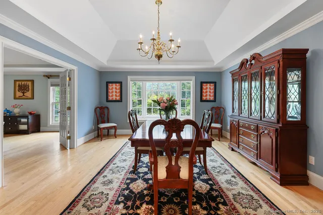 a view of a dining room with furniture a chandelier and wooden floor