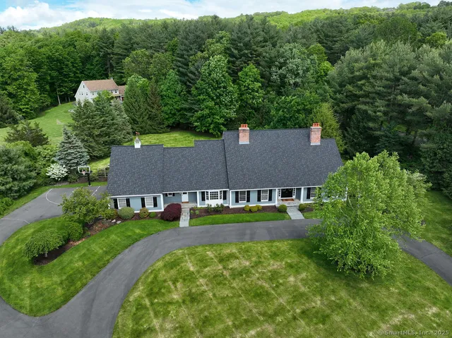 an aerial view of residential houses with outdoor space and trees