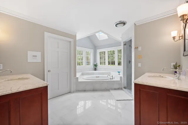 a spacious bathroom with a tub sink and mirror