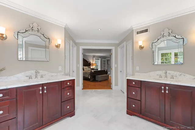 a en suite bathroom with a granite countertop sink and mirror