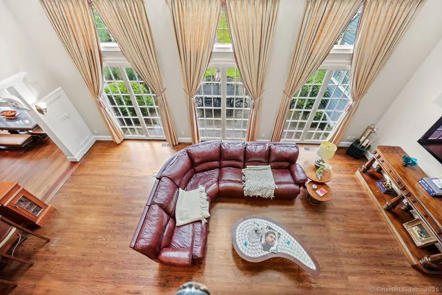 a view of a livingroom with furniture hardwood floor and windows