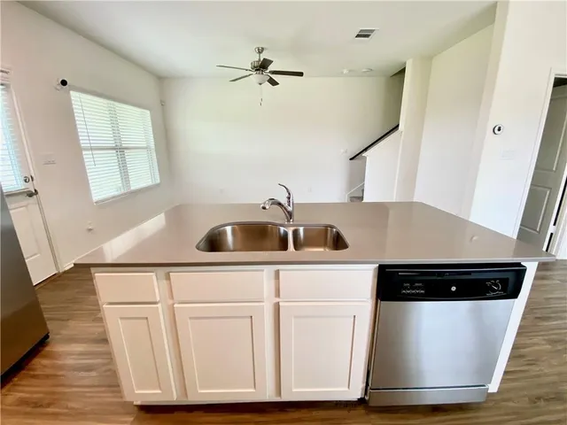 a kitchen with sink and white cabinets