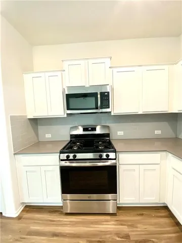 a stove top oven sitting inside of a kitchen