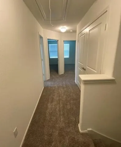 a view of a hallway with wooden shelves