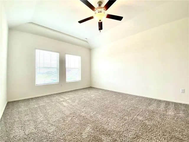 an empty room with a window and a ceiling fan