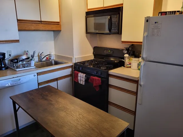 a kitchen with stainless steel appliances granite countertop a stove a refrigerator and a microwave