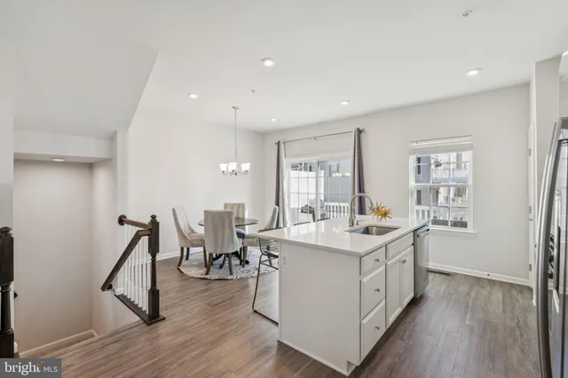 a room with a sink wooden floor and white cabinets